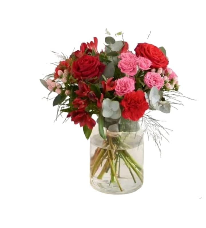 Ramo de rosas rojas y claveles rosas en jarrón